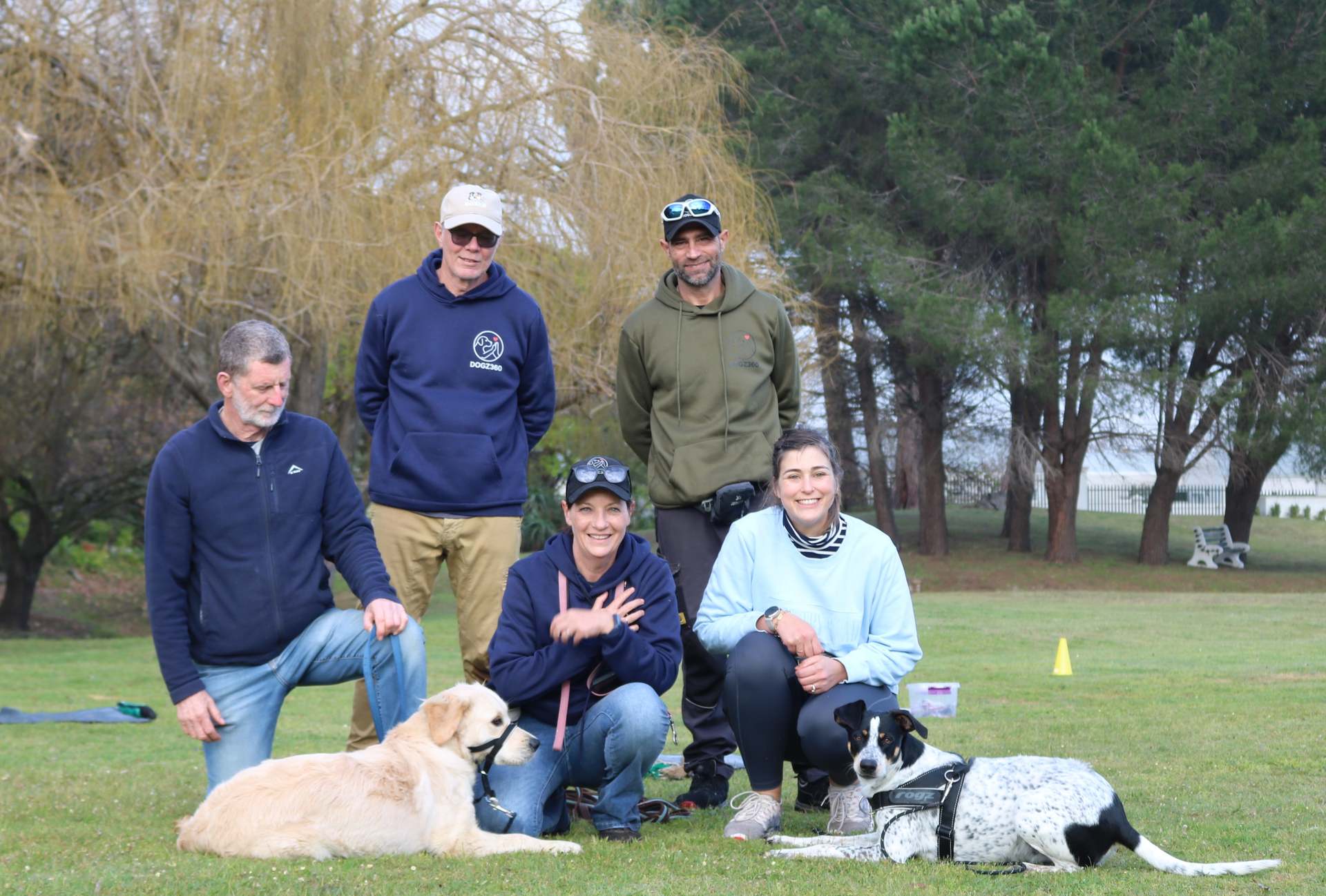 Class group kneeling with a golden retriever and a spotted dog